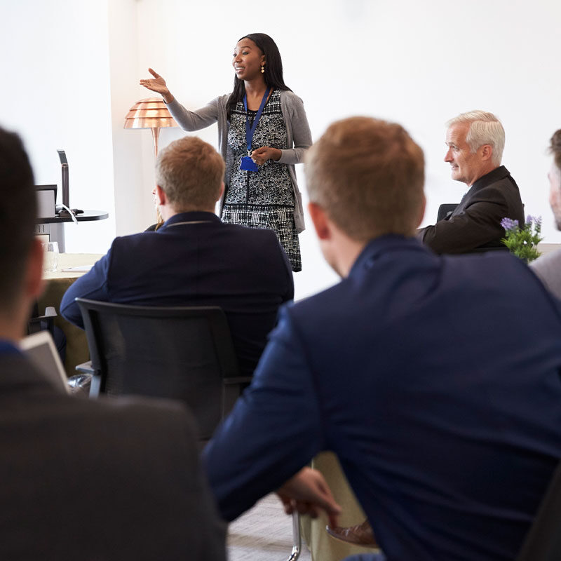 A woman talking to a group of business people